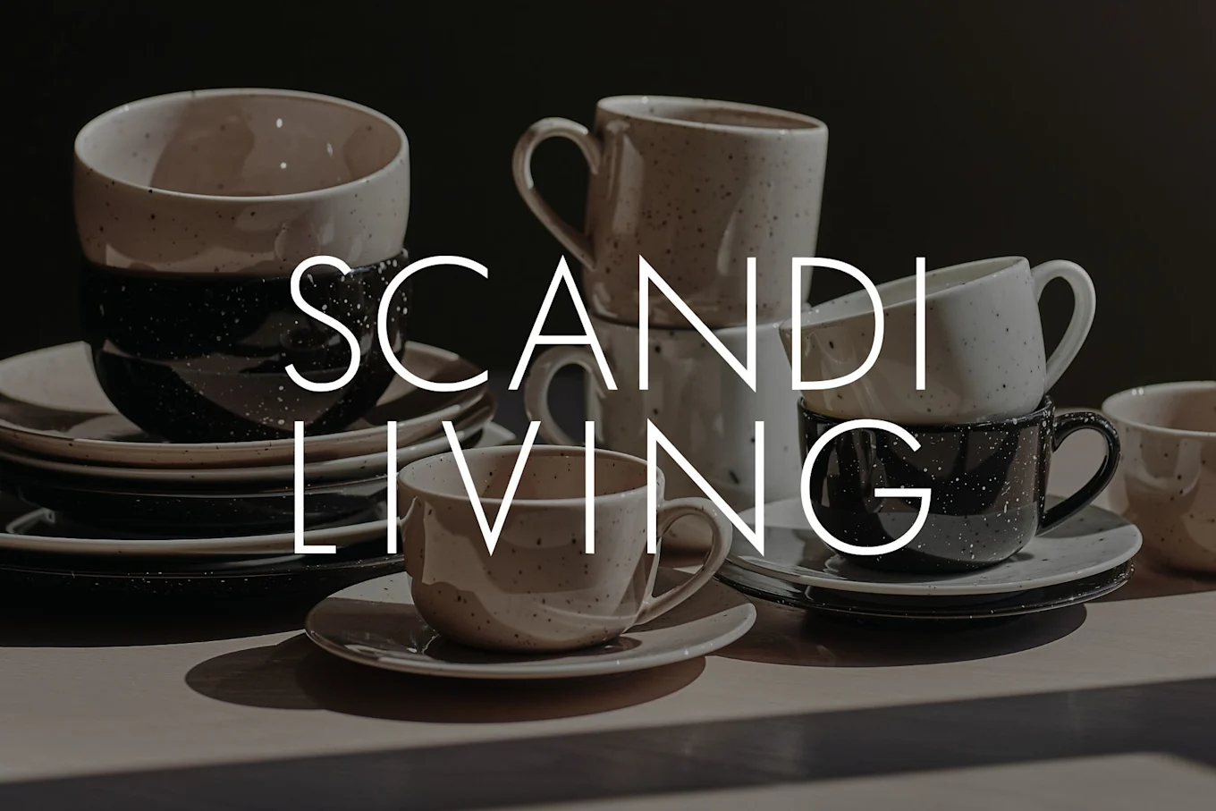 ベージュと黒の斑点模様のセラミックカップ、マグカップ、皿がテーブルに積まれ、「SCANDI LIVING」の文字が重なっている。