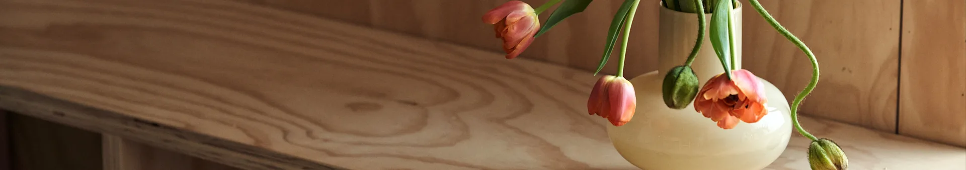 ノルディックネストで、インテリアデザインのヒントや最新のインテリアトレンドをチェック。Marimekko/マリメッコのイエローの花瓶に、オレンジのチューリップを挿して。
